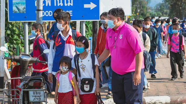 KANCHANABURI, THAILAND-JANUARY 14. 2022: Okuldan eve dönerken Corona virüsünü (COVID-19) önlemek için beş farklı milletten (Tayland, Lao, Mon, Karen ve Birmanya) öğrenciler maske takıyor.