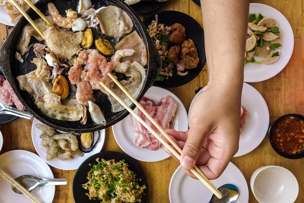 Bbq 바베큐먹기 사람들은 뜨거운 스토우 요리하기 위하여 뜨거운 남비에 젓가락을 — 스톡 사진