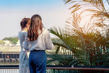 Çekici Asyalı kadın yolcuların arka plan portresi hafta sonu gezisi sırasında Riverside 'da dijital kamerayla fotoğraf çekiyor. Kadın arkadaşlarının mutluluğu ve dostluğu. Çekim ve seyahat kavramı