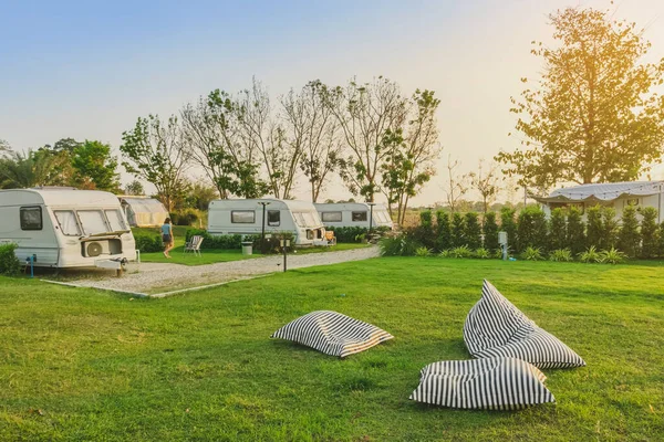 Pillow or mattress for relax on green grass with Cozy retro travel trailer Caravan near riverside in peaceful countryside.Family vacation travel RV, holiday trip in motorhome.Outdoor and Recreational