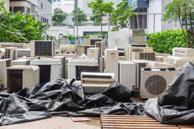 A lot of Air conditioners stacked up in a pile to disposal at recycling garbage dump. Stack of old and dirty air conditioners defective and discarded for recycling process industry. Old appliances.