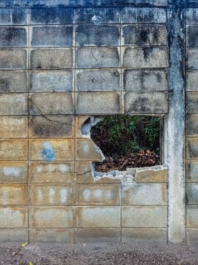 Dirty old eroded cracked plaster cement block fence. Concrete block wall. Destroyed crumbling cement mortar texture. Background of wall. Brick texture with scratches and cracks. brick wall background