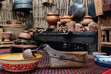 Variety and types of utensils for simple cooking of Asian families in the past. Traditional Asia and Thai old kitchen style interior. Antique kitchen with utensils at bamboo cottage. Selective focus.