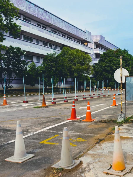 Driving test and training area with simulate test for driving license. Driving school practice traffic area with pole signs and orange cones and road signs for safety on concrete road. Selective focus.