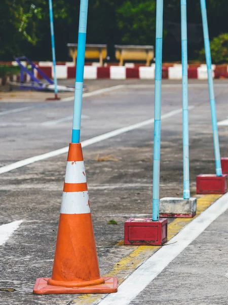 Driving test and training area with simulate test for driving license. Driving school practice traffic area with pole signs and orange cones and road signs for safety on concrete road. Selective focus.