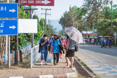 KANCHANABURI, THAILAND-JANUARY 14. 2022: Okuldan eve dönerken Corona virüsünü (COVID-19) önlemek için beş farklı milletten (Tayland, Lao, Mon, Karen ve Birmanya) öğrenciler maske takıyor.