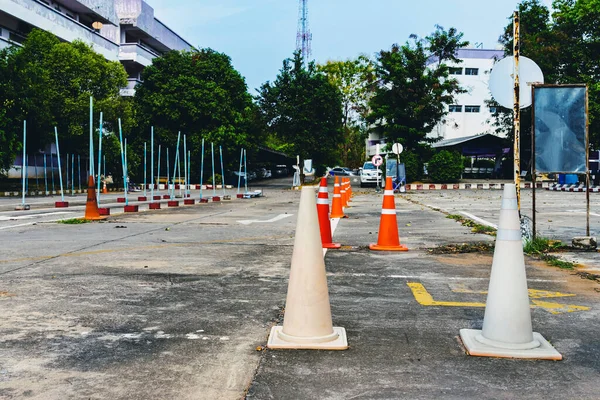 Driving test and training area with simulate test for driving license. Driving school practice traffic area with pole signs and orange cones and road signs for safety on concrete road. Selective focus.