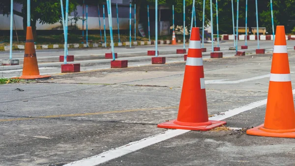 Driving test and training area with simulate test for driving license. Driving school practice traffic area with pole signs and orange cones and road signs for safety on concrete road. Selective focus.