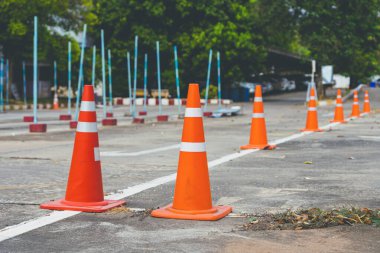 Driving test and training area with simulate test for driving license. Driving school practice traffic area with pole signs and orange cones and road signs for safety on concrete road. Selective focus.