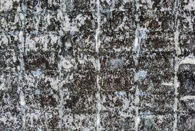 Dirty old eroded cracked plaster cement block fence. Concrete block wall. Destroyed crumbling cement mortar texture. Background of wall. Brick texture with scratches and cracks. brick wall background