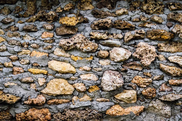 Old style wall made of rough stones with cement. Ancient grunge stones wall backdrop. Background of old vintage wall.Ancient style stone fence decoration to be beautiful and strong with natural stone.