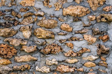 Çimentodan yapılmış eski tarz bir duvar. Antik grunge taşı duvar zemin. Eski model duvar. Eski tarz taş çit dekorasyonu. Doğal taşlarla güzel ve güçlü olmak için..