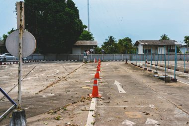 Driving test and training area with simulate test for driving license. Driving school practice traffic area with pole signs and orange cones and road signs for safety on concrete road. Selective focus.