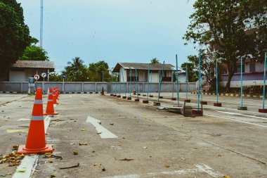 Driving test and training area with simulate test for driving license. Driving school practice traffic area with pole signs and orange cones and road signs for safety on concrete road. Selective focus.