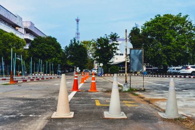 Driving test and training area with simulate test for driving license. Driving school practice traffic area with pole signs and orange cones and road signs for safety on concrete road. Selective focus.
