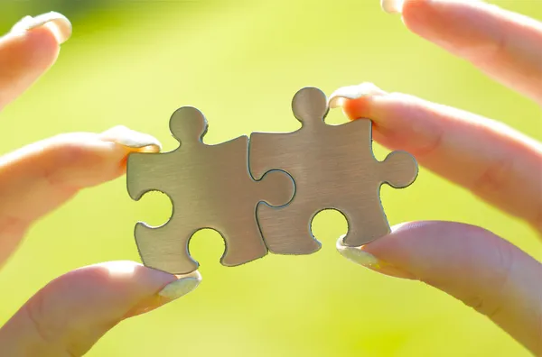 Vrouw handen met puzzelstukjes — Stockfoto