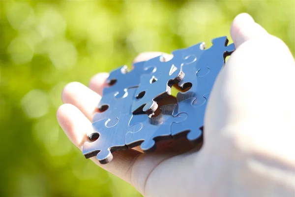 Handing set of puzzle pieces — Stock Photo, Image