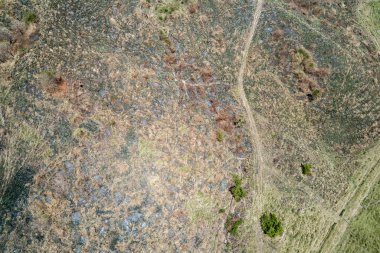 Yüksek drone hava manzarası deseni, renklerin arasından geçen patikalarla bir dağın çıplak tarafına bakıyor.