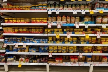 Mackay, Queensland, Avustralya - Ekim 2021: Fıstık ezmesi ve vegemite dahil olmak üzere süpermarket raflarında satılık şişeler