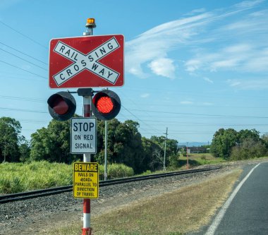 Railway crossing stop go signs with red signal on, rural train tracks clipart
