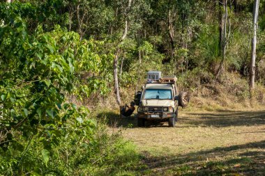 Mackay, Queensland, Avustralya - Ekim 2021: Kamp için hazırlanan aracının gölgesinde dinlenen bir gezgin