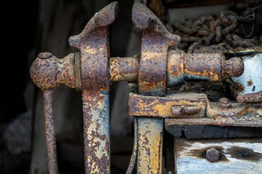 Eski bir vintage klemp nesnesi. Diğer antika eserlerin arasında bir kulübede paslanmış.