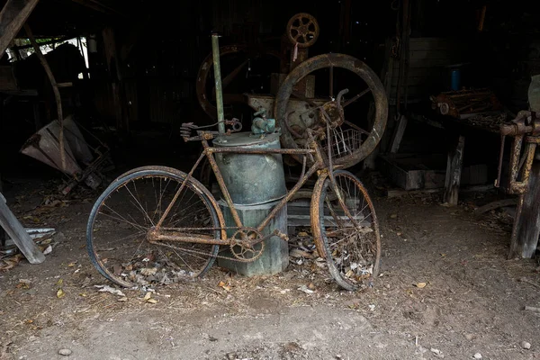 陈年旧车陈旧不堪的老式自行车 陈列在一个满是旧物和旧时代工具的小木屋里 — 图库照片