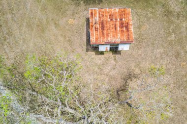 Çıplak ağaçların arasındaki paslanmış eski bir barakanın yukarıdan görünüşü - insansız hava aracı hava manzarası