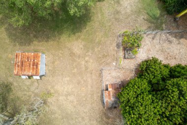 Ağaçlar arasındaki iki barakanın yukarıdan görünüşü - İHA hava sahası