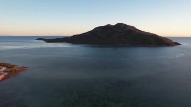Okyanusu ve adayı kaplayan çalılıklardan gelen hava taraması Mercan Denizi 'nin üzerindeki Cape Gloucester Queensland Avustralya' da gün doğumuna doğru sürdü.