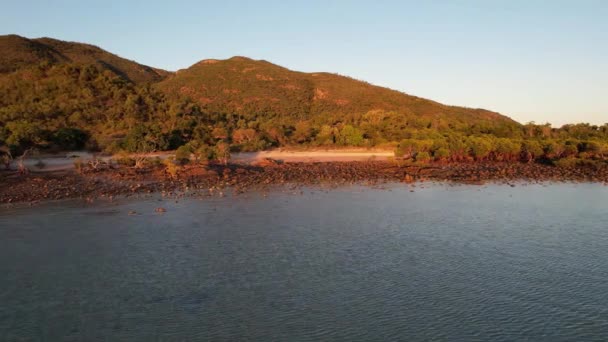 無人機が着陸する際に岩の多いビーチ上の日の出の暖かい朝の光 ケープグロスター クイーンズランド州 オーストラリア — ストック動画