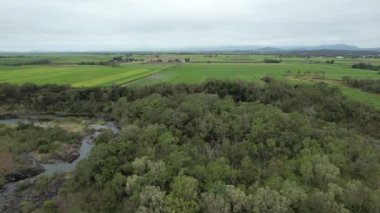 Tarım arazisinin havadan tavası ve çalılık, su korunması için kayalık bir nehri kaplayan Weir 'ın duvarına doğru ilerliyor.
