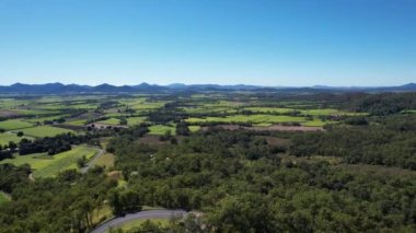 Uzakta bulunan şeker kamışı otlaklarının görüntüsü tarımın yeşil bir modelini oluşturuyor, Mackay Queensland, Avustralya