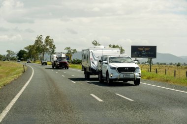Bruce Highway Mackay 'den Townsville, Queensland, Avustralya' ya - Kasım 2021: Karavanları tatil yollarına çeken iki araba