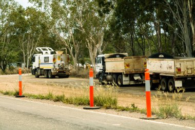Bruce Highway Mackay 'den Townsville, Queensland, Avustralya' ya - Kasım 2021: Kamyon taşımacılığı toprağı ve yol inşaatındaki tozları sulamak için bir diğeri