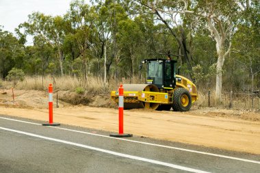 Bruce Highway Mackay 'den Townsville, Queensland, Avustralya' ya - Kasım 2021: Otoyol kopyalama inşaatında çalışan ağır bir makine silindiri