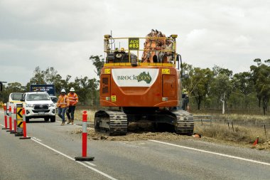 Bruce Highway Mackay 'den Townsville, Queensland, Avustralya' ya - Kasım 2021: Otoyol inşaatı sırasında otoyol inşaatı yapan dev makinelerin yanında inşaat işçileri