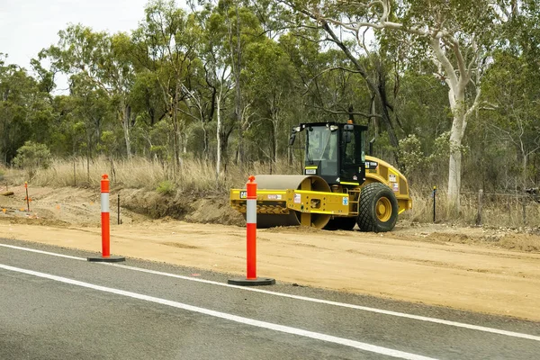 Bruce Highway Mackay 'den Townsville, Queensland, Avustralya' ya - Kasım 2021: Otoyol kopyalama inşaatında çalışan ağır bir makine silindiri