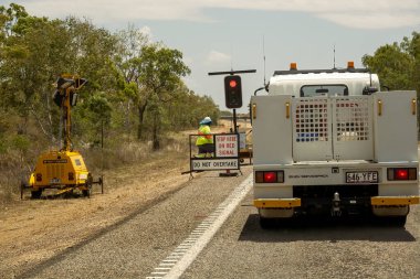 Mackay 'dan Townsville Bruce Highway' e, Queensland, Avustralya - Kasım 2021: Trafiği denetleyen işçiyle yol inşaatı sırasında kırmızı ışıkta duran kamyon