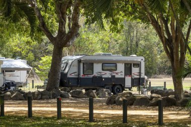 Townsville, Queensland, Avustralya - Kasım 2021: Karavanlardaki tatilciler ağaçların altındaki ücretsiz kamp parkında