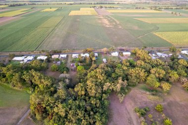 Güneş bir köy kasabasının ve şeker kamışı tarlalarının üzerinde batarken, yeryüzündeki yumuşak turuncu ışık