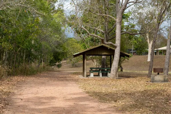 一个有座位和烤铁的野餐棚 在枯叶丛中 — 图库照片