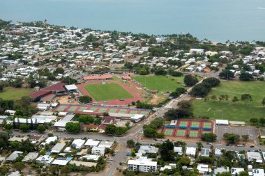 Townsville, Queensland, Avustralya - Kasım 2021: Castle Hill 'den atletizm pistine ve deniz kenarındaki evlerin tenis kortlarına bakmak