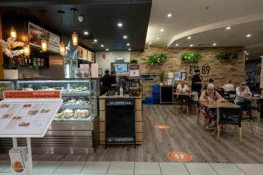 Townsville, Queensland, Avustralya - Kasım 2021: Müşteriler yemek vitrinli popüler bir kahve dükkanında yemek yiyorlar