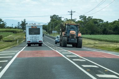 Bruce Highway, Townsville 'den Mackay' e, Queensland, Avustralya - Kasım 2021: Karavan ve traktör karayolunda şeker kamışı taşıyor