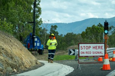 Bruce Highway, Townsville 'den Mackay' e, Queensland, Avustralya - Kasım 2021: Yol inşaatında çalışan kadın trafik denetçisi