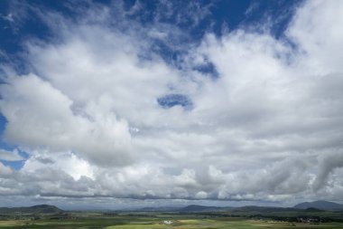 Bulutlu mavi gökyüzünün arazi üzerindeki insansız hava aracı manzarası