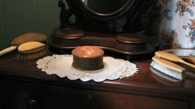 Düşes, aynalı antika mobilyaların üzerinde antika saç fırçaları ve mücevher kutusu.