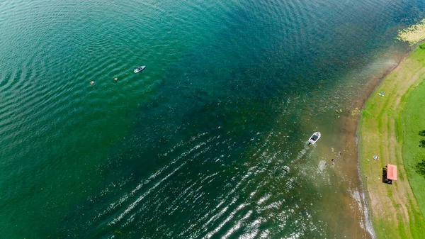 ダムの水の向こうにインフレータブルチューブに人々を引っ張るパワーボート — ストック写真