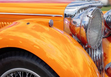 Sevgiyle restore edilmiş turuncu renkli bir arabanın parlaklığına yakın.